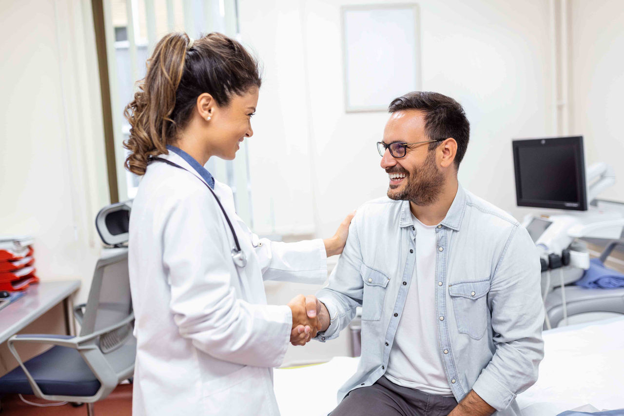 Aperto de mão entre médica e paciente